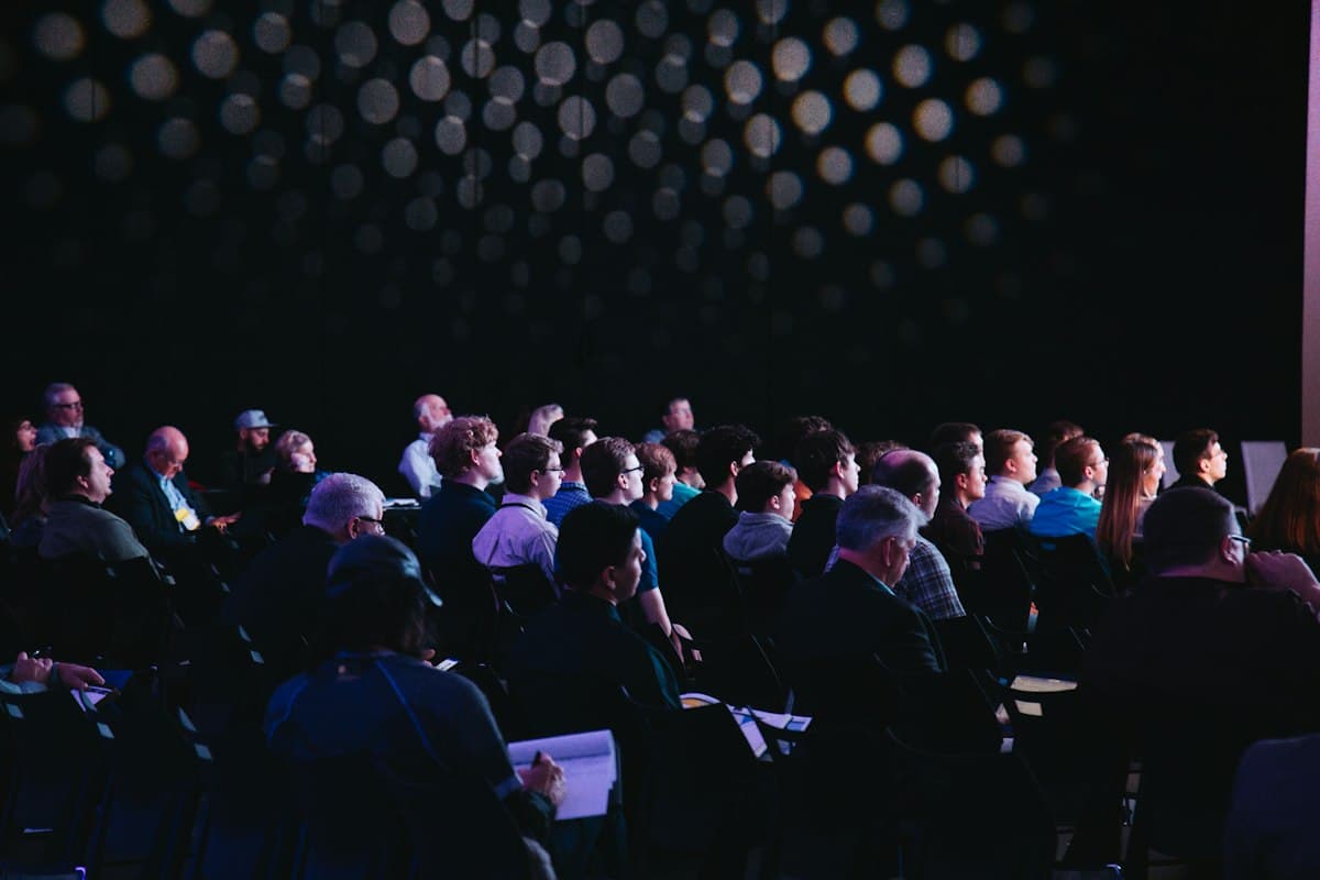 Audience at a meetup with speakers on stage